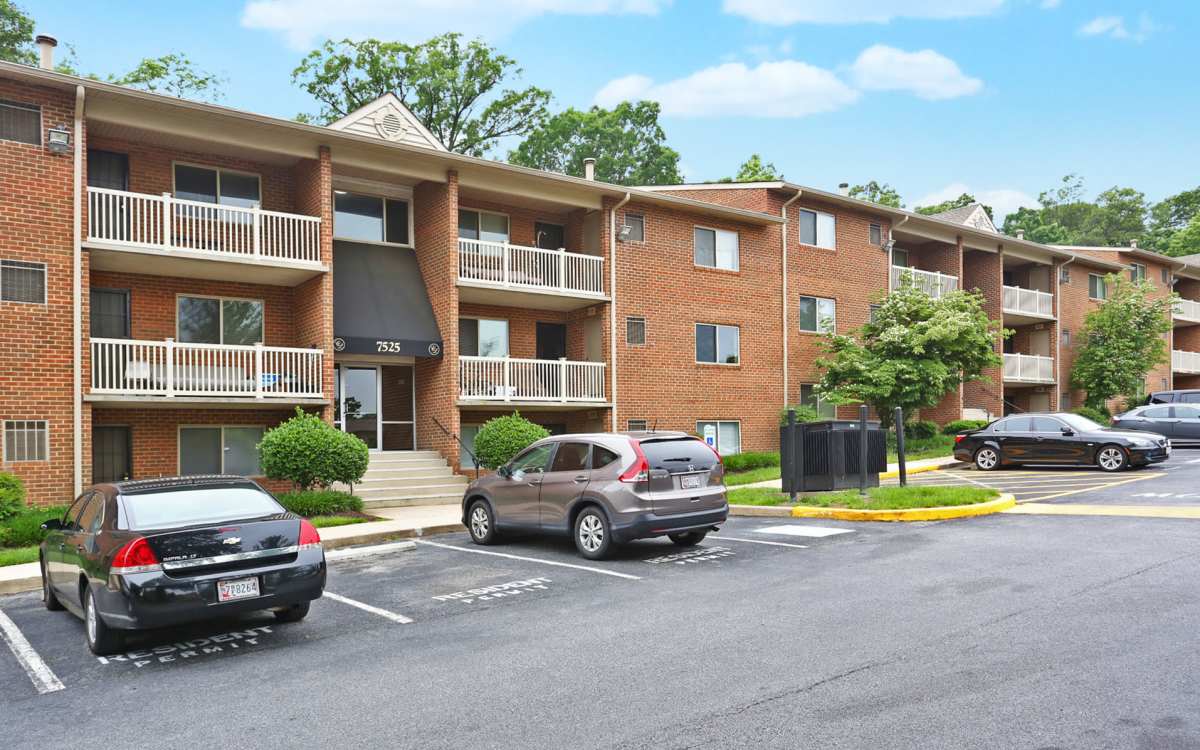 Exterior shot of apartments with street parking and balconies at Chesapeake Landing Apartments in Landover Hills, Maryland