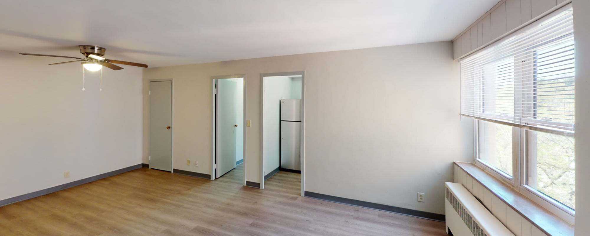Open layout living room with ceiling fan at Lebanon Vue in Pittsburgh, Pennsylvania