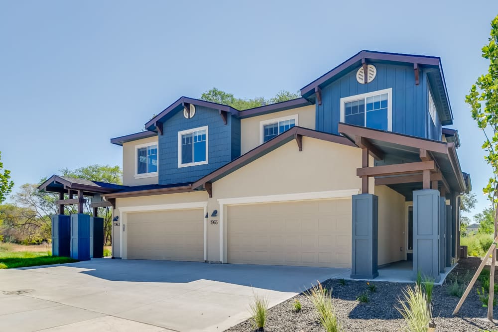 Exterior of  high-end, two-story townhomes with garages and a wide driveway at Olympus at Ten Mile in Meridian, Idaho