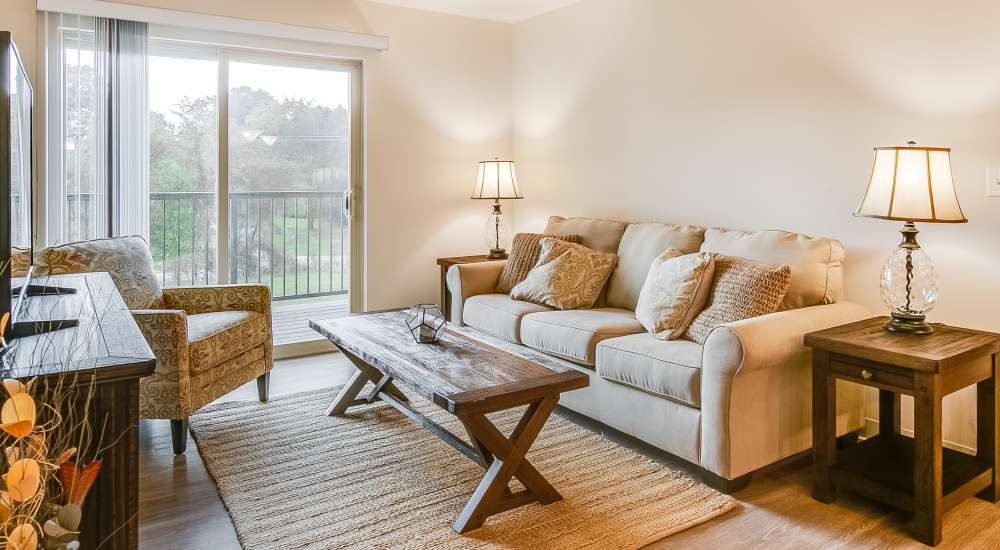 Cozy living room with couch and large windows at Chelsea Commons in Sugar Grove, Illinois