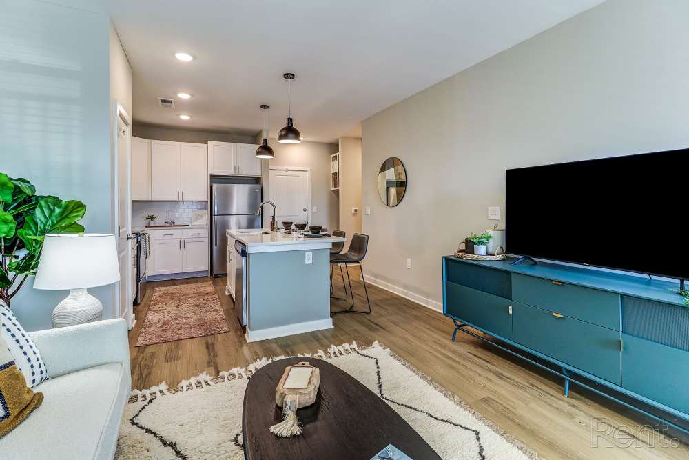 Open layout living room with hard-wood style flooring and plenty of room for a couch, chair, TV, plants at Mosby Bridge Street in Huntsville, Alabama