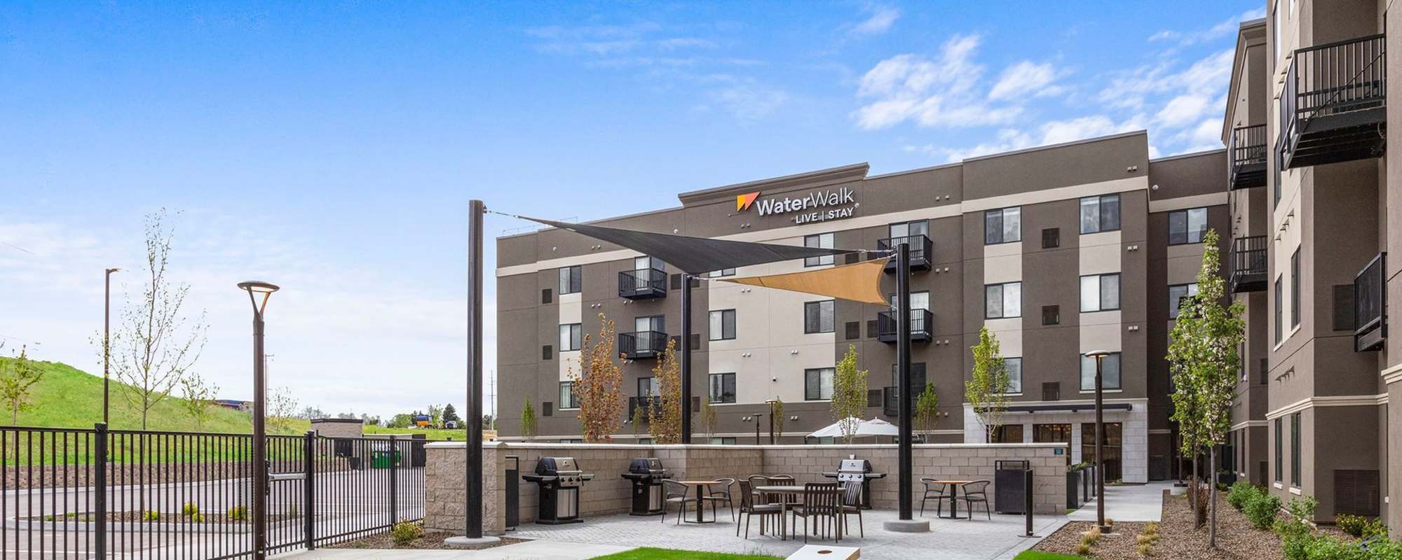 Modern multi-story apartment community with private balconies and street-facing entrance at WaterWalk Boise - Meridian in Meridian, Idaho
