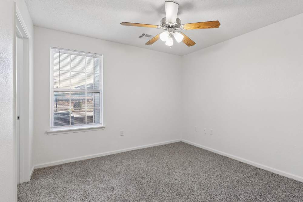 Charming bedroom with plush carpeting and abundant natural light at Covington Woods Apartments in Lansing, Kansas.