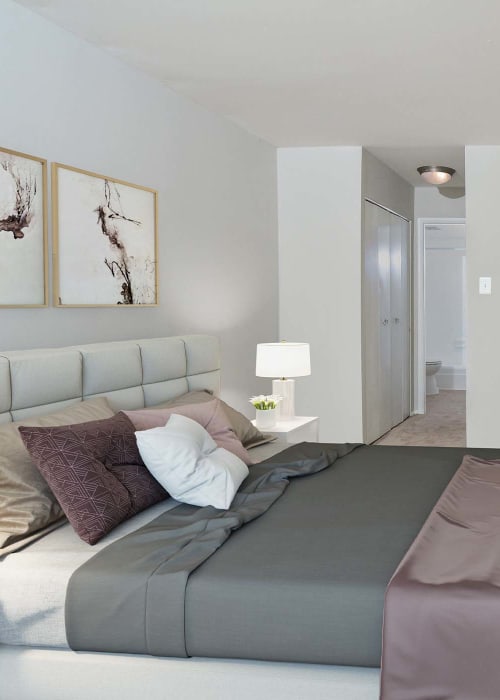 Model bedroom with plush carpeting and a ceiling fan at Landmark Glenmont Station in Silver Spring, Maryland