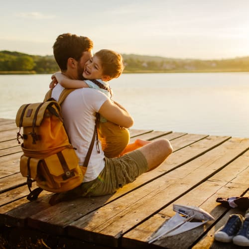 Resident and son embracing on a dock near Station at Lake Murray in Columbia, South Carolina