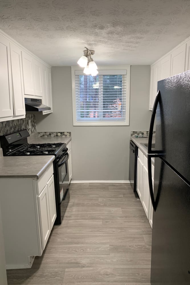 An apartment kitchen with black appliances at Foxwood Apartments in Doraville, Georgia