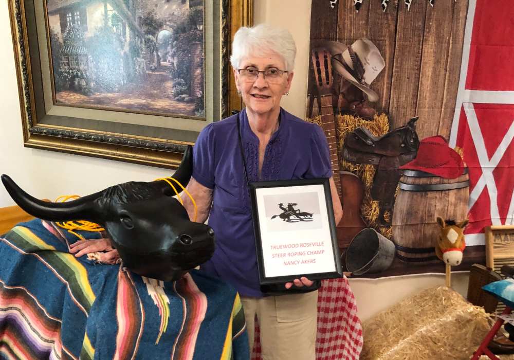 Resident posing with a book at Truewood by Merrill, Roseville in Roseville, California
