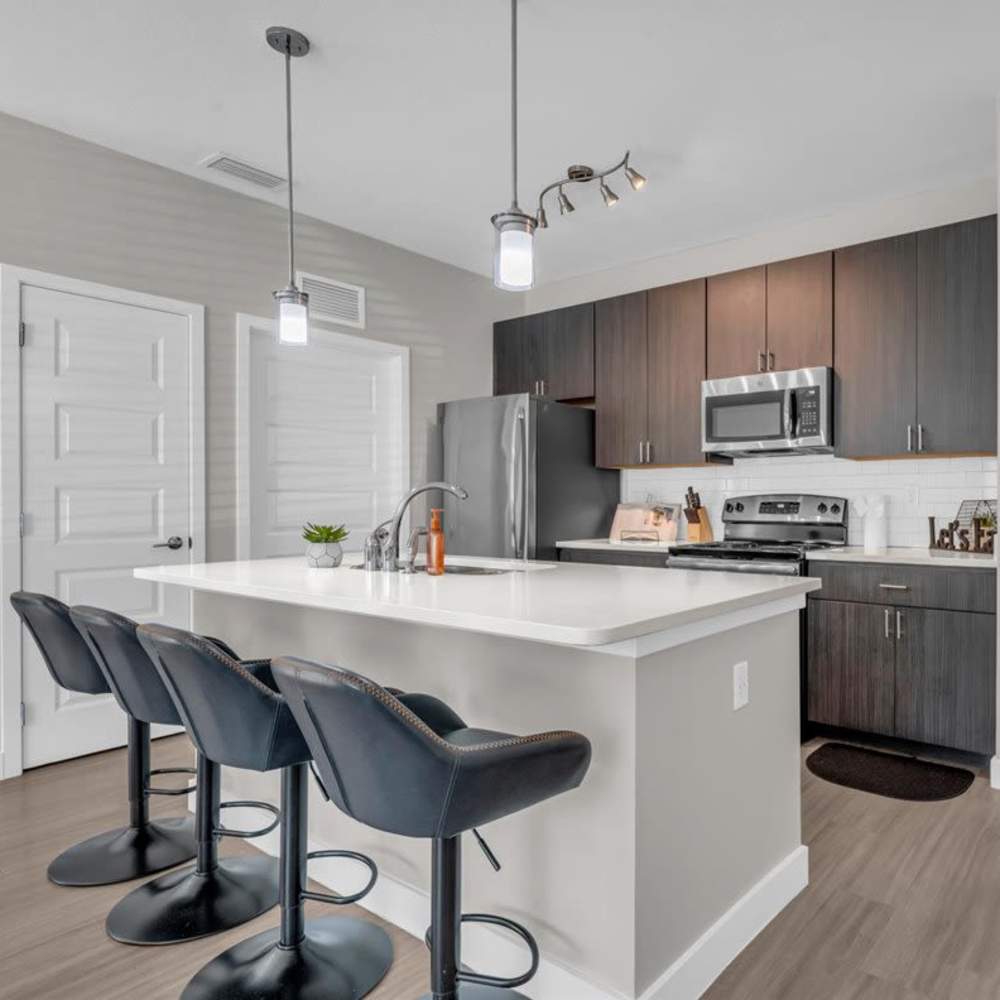 Modern kitchen with island and stainless steel appliances at 81 West Apartments in Fort Myers, Florida