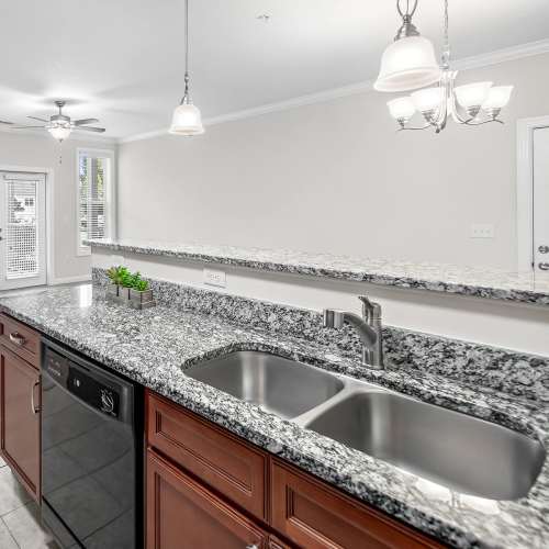 Kitchen with built-in dishwasher and wood cabinetry at Brittany Place Hendersonville in Henderson, North Carolina
