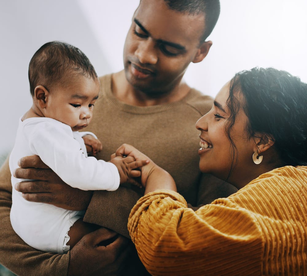 A mother and father with their child at The Oaks of St. Clair in Moody, Alabama