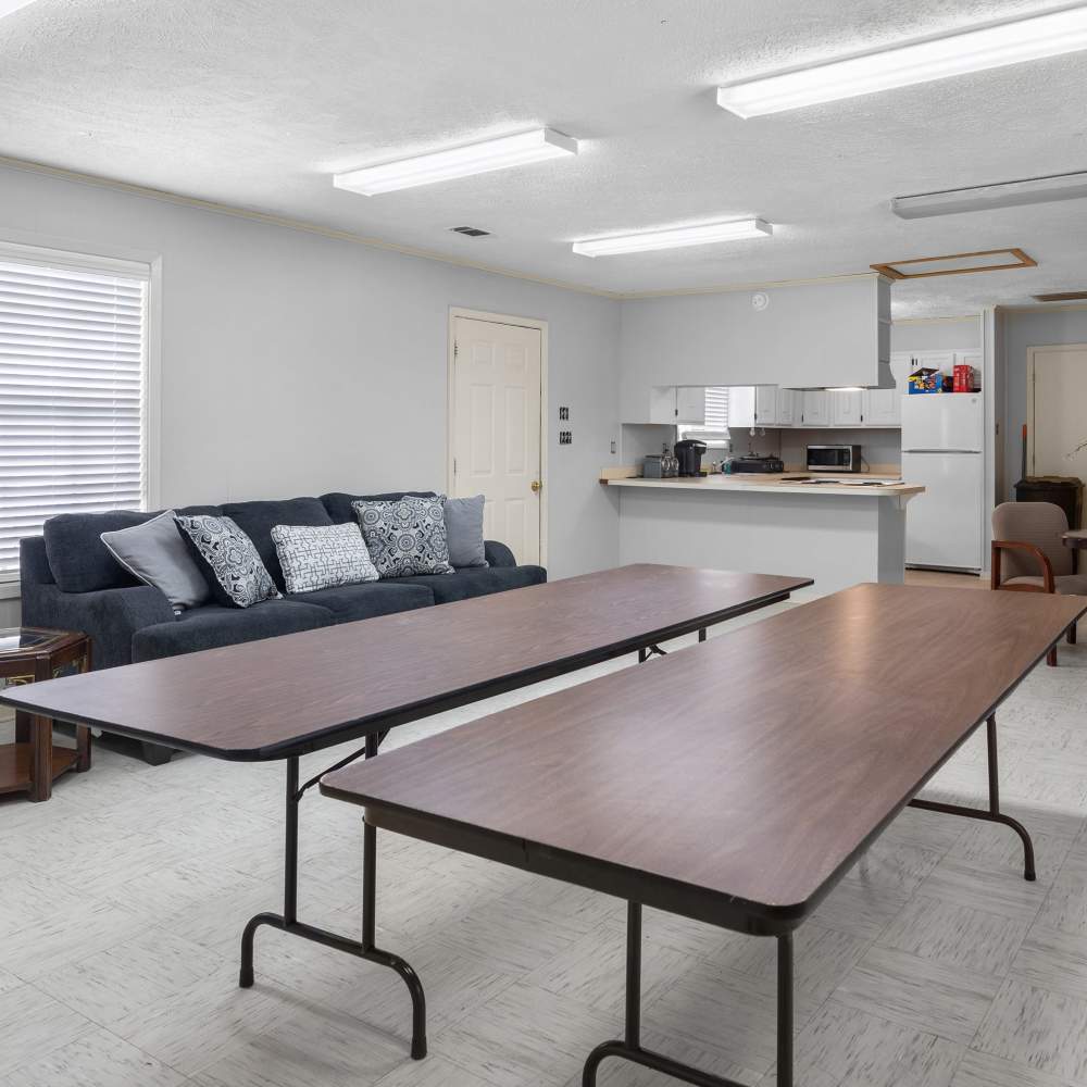 Bright and inviting open space with a cozy couch and modern kitchen area at Pecan Ridge in Vicksburg, Mississippi.