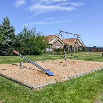 Playground with a seesaw and swing at Oak Run Apartments in Columbus, Ohio.