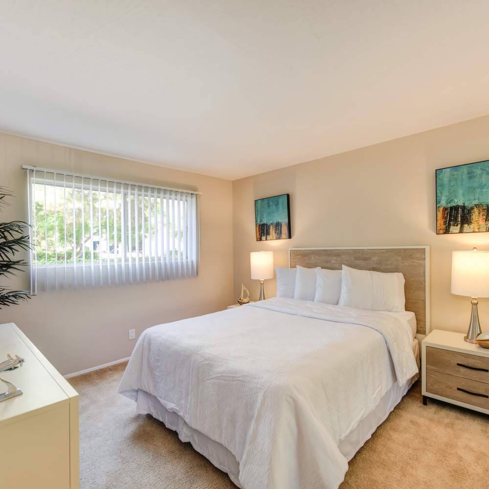 Bedroom with carpet flooring and large window at Glenwood Garden Apartments in Mountain View, California