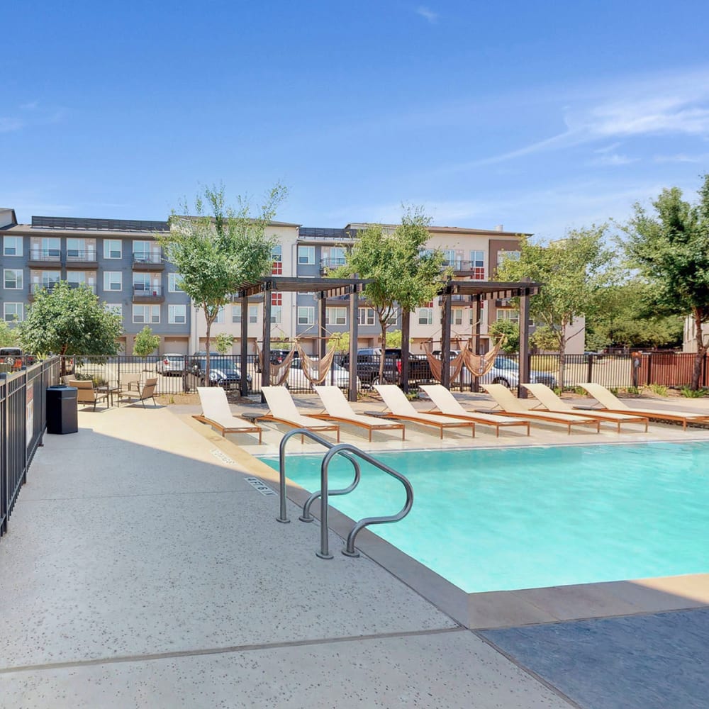 Chaise lounge chairs beside the swimming pool at Oaks Trinity in Dallas, Texas