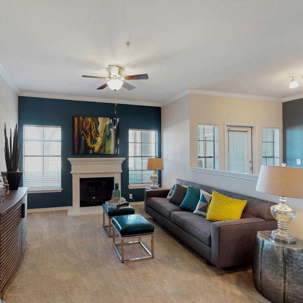 Fireplace and plush carpeting in the living area of a model home at Oaks Riverchase in Coppell, Texas