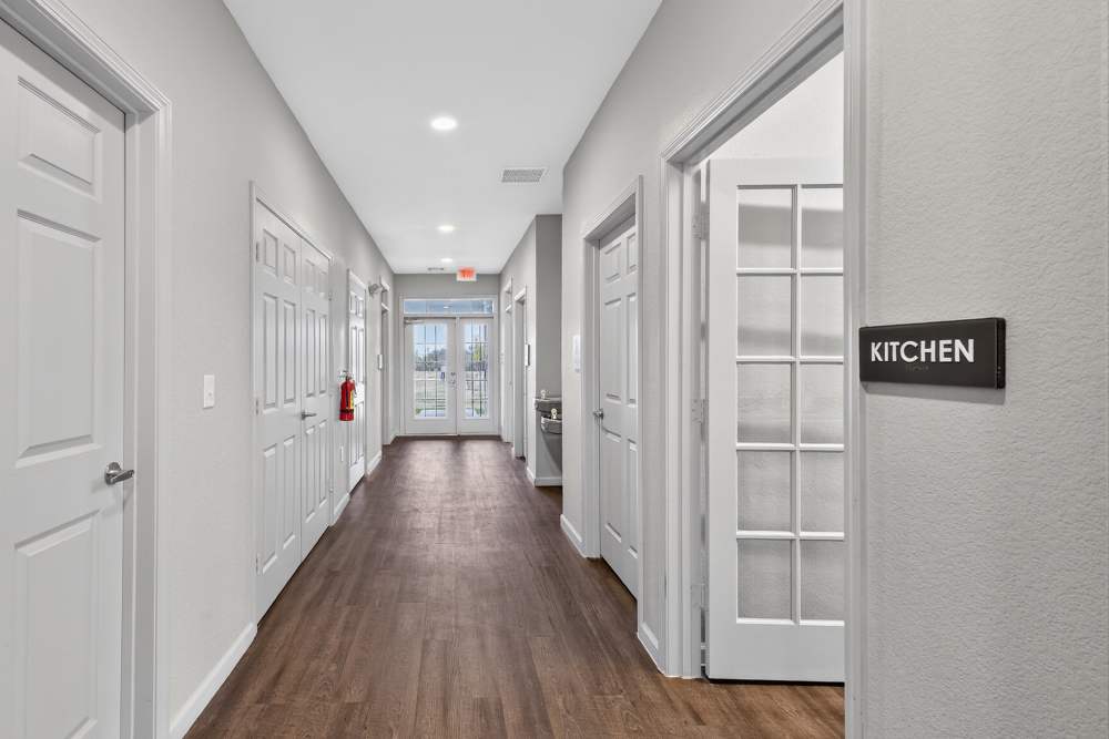 Charming hallway leading to a modern kitchen at Lakewood Crossing in Granbury, Texas.