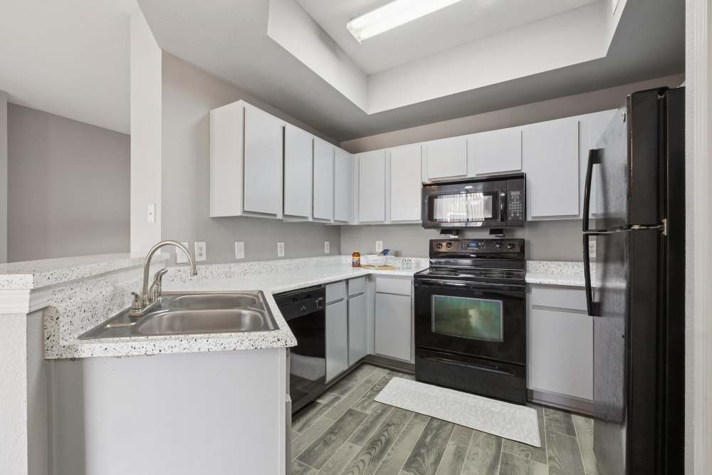 Stainless steel appliances and granite countertops of apartment kitchen at Lansbourough in Houston, Texas