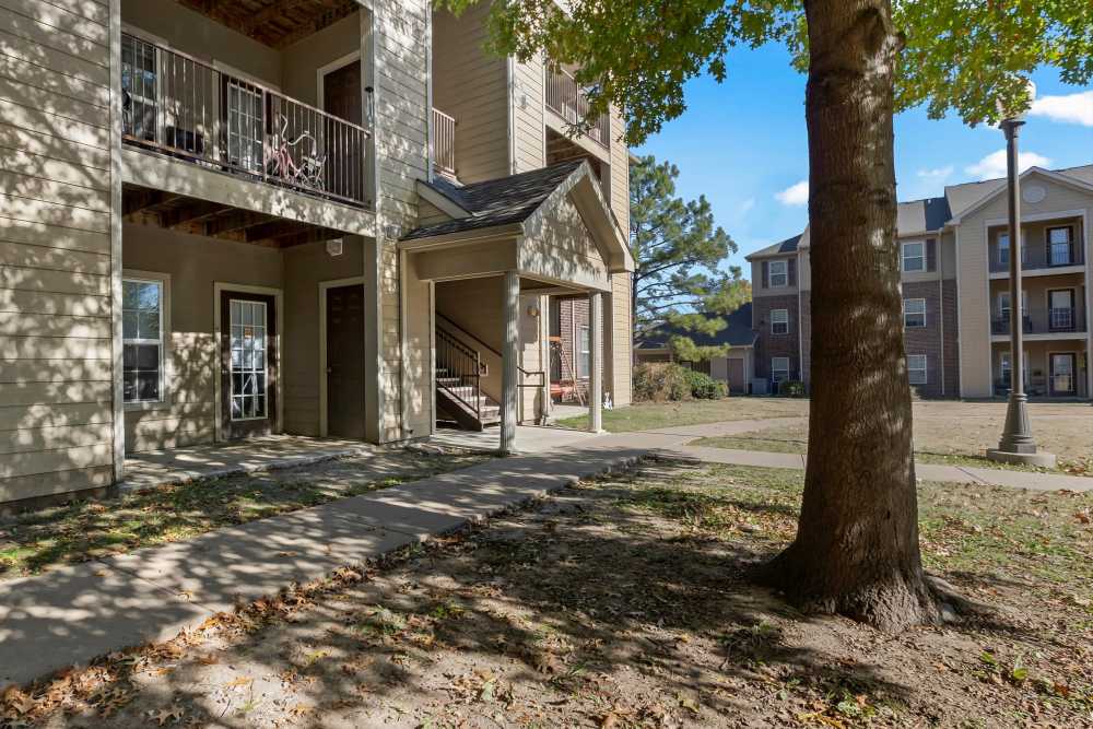 Charming exterior with lush landscaping and inviting porch at Rolling Meadows Apartments in Glenpool, Oklahoma.