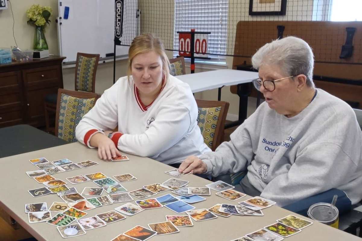 A resident and a employee playing a game at Isle at Raider Ranch