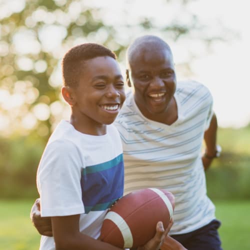 a father and son playing football at North Severn Village in Annapolis, Maryland