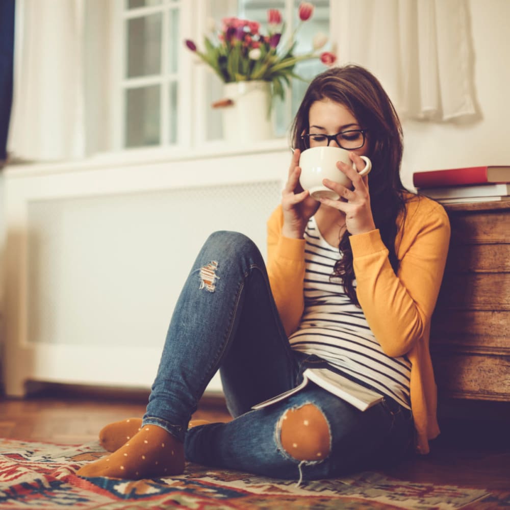 Resident enjoying a hot cup of tea in her apartment at The Villas at Woodland Hills in Woodland Hills, California
