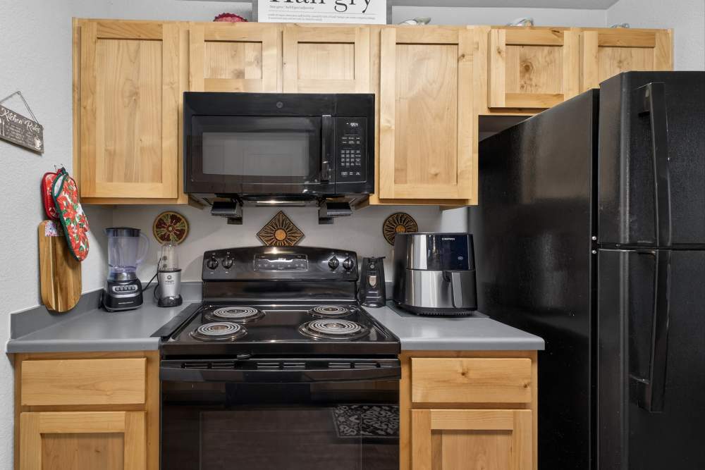 Charming modern kitchen with natural wood cabinetry and sleek appliances at Lakewood Crossing in Granbury, Texas.