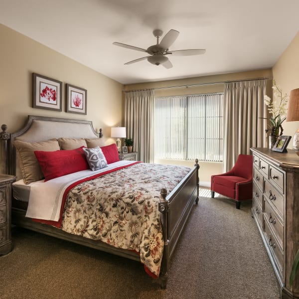 Well-decorated master bedroom with ceiling fan of model home at San Portales in Scottsdale, Arizona