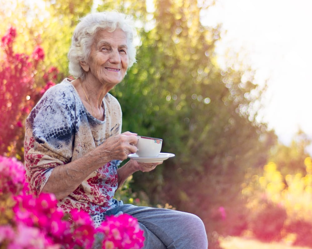 A resident enjoying a drink outside at The Arbors at Heritage Place in Lexington, Tennessee