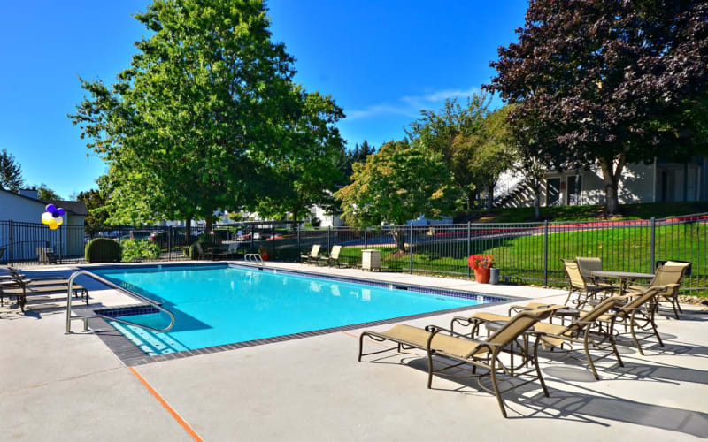 Seating near the swimming pool on a sunny day at Wellington Apartment Homes in Silverdale, Washington