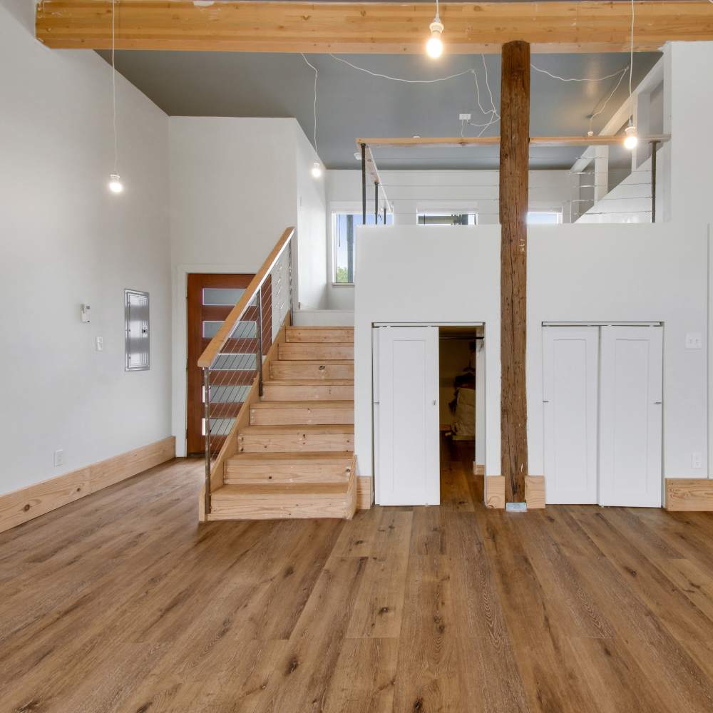 Living room with wooden stairs at The Lofts at 305 in Bryan, Texas