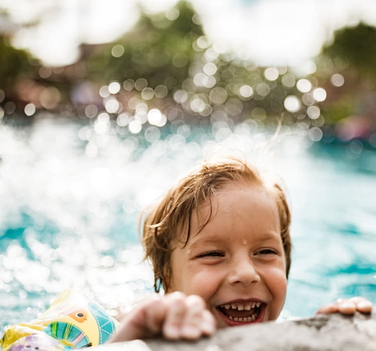 Child playing in his new pool on a hot summer day at Trails at Lake Houston in Houston, Texas