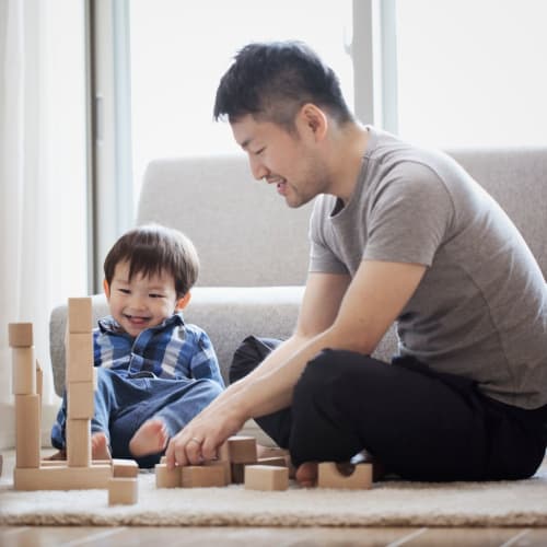 A resident and his son playing with blocks in their living room at Hilleary Park in San Diego, California