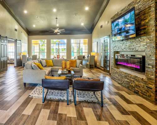 Spacious clubhouse living room with couch, fire place and television at Las Ventanas in Alamogordo, New Mexico