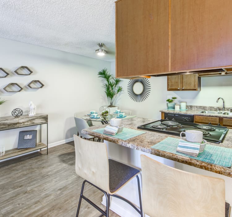 Beautiful hardwood flooring and granite countertops in the kitchen and dining areas of a model home at Sofi Poway in Poway, California