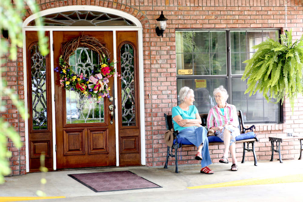 Two residents sitting outside talking at Providence Assisted Living.