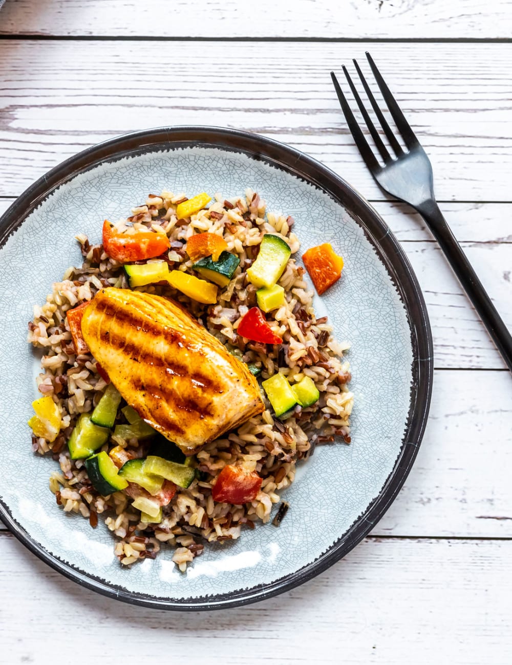 A plate of delicious chicken and rice with vegetables