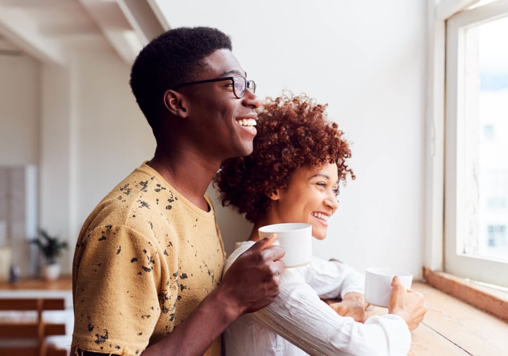 Couple enjoying their morning cup of coffee and looking out the window of their apartment home at Woodrum Manor/Westview in Pearisburg, Virginia