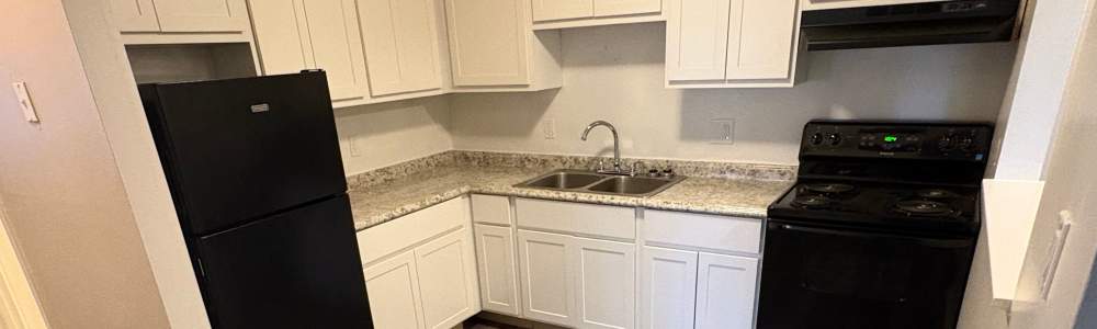 Kitchen with black appliances at Tanglewood Apartments in Hammond, Indiana