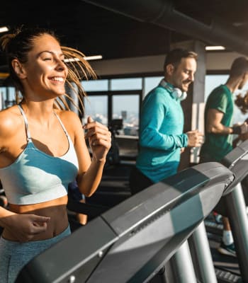 Residents running on treadmills in fitness room at University Lofts at Greensborough Village, Jonesboro, Arkansas