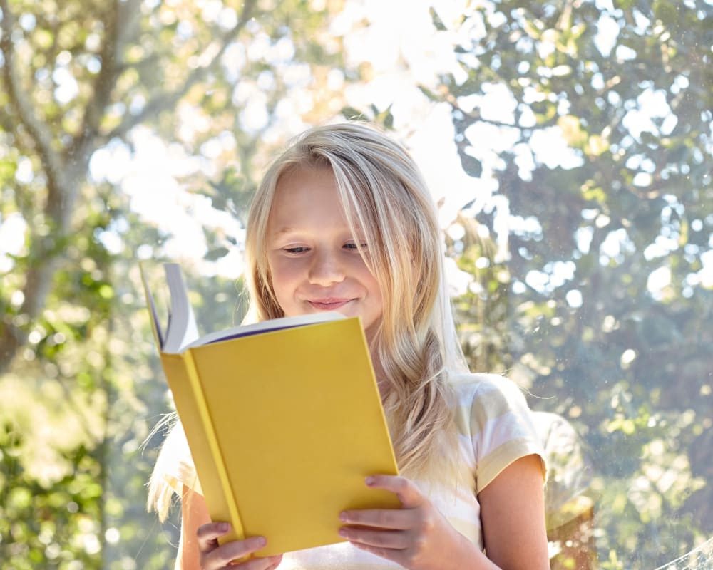 Resident student reading a book in her new home at Sofi Dublin in Dublin, California