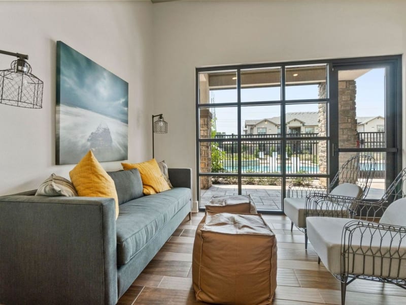 Comfortable and inviting resident lounge space with pool views at Auberge of Tyler in Tyler, Texas