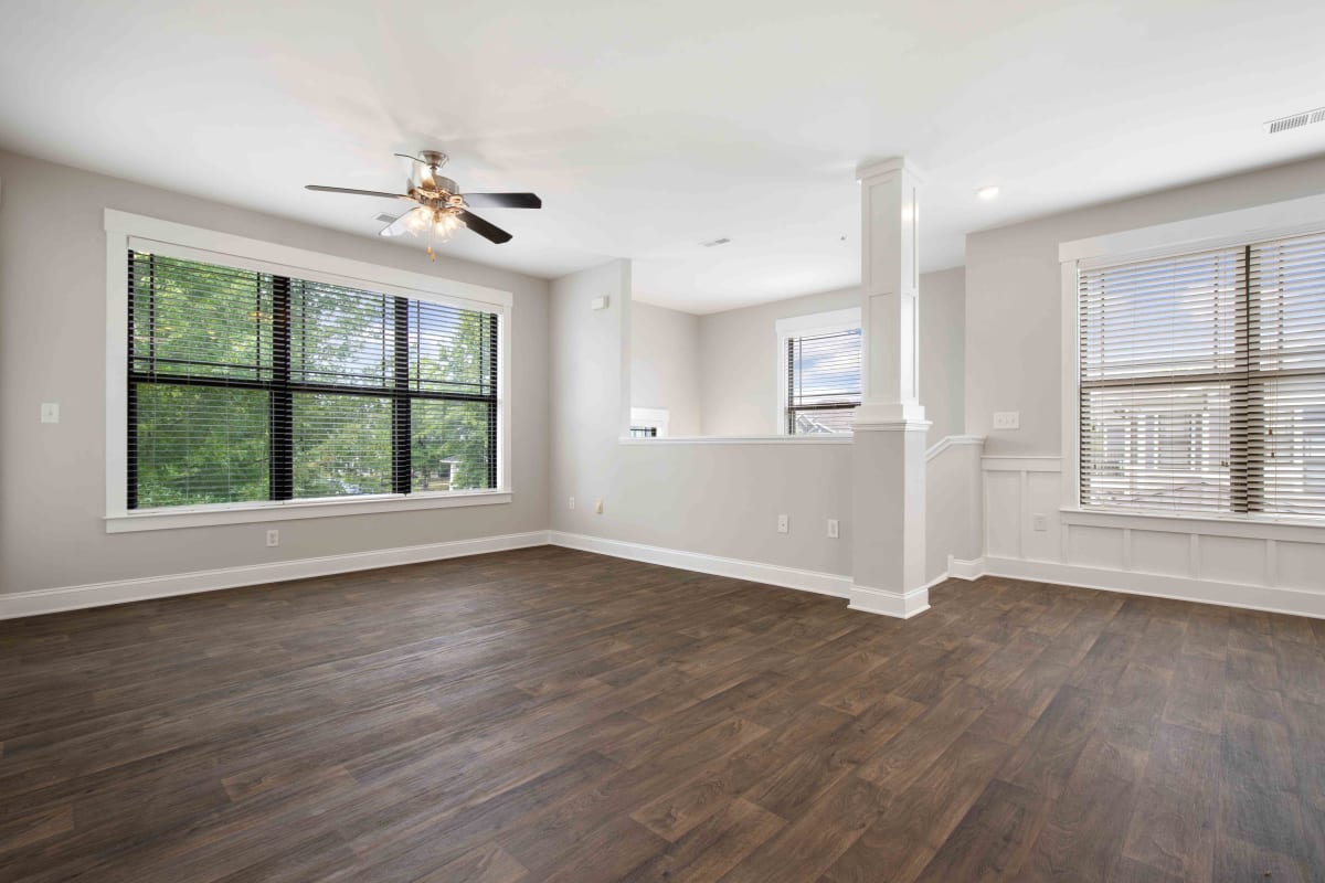 Apartment living room with wood-style flooring at The Apartments At Blakeney in Charlotte, North Carolina