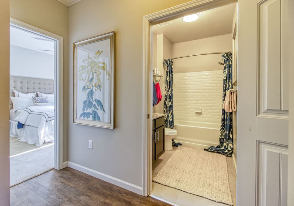 Modern bedroom and bathroom with white tile back-splash in shower and tub at Everwood at The Avenue in Murfreesboro, Tennessee