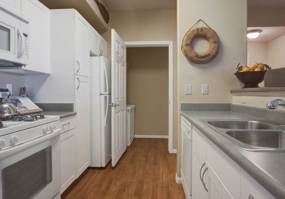 Modern kitchen with white cabinets , stove and stainless sink at Rivers Edge in Lake Elsinore, California
