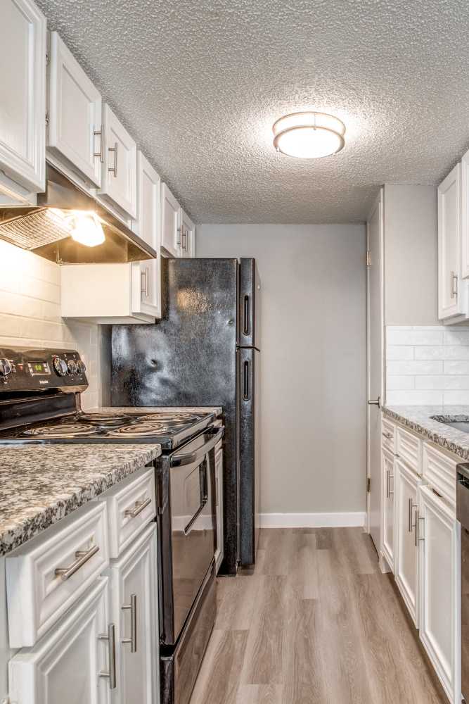 Kitchen with hardwood flooring in a model apartment at Villa De Oro in San Antonio, Texas