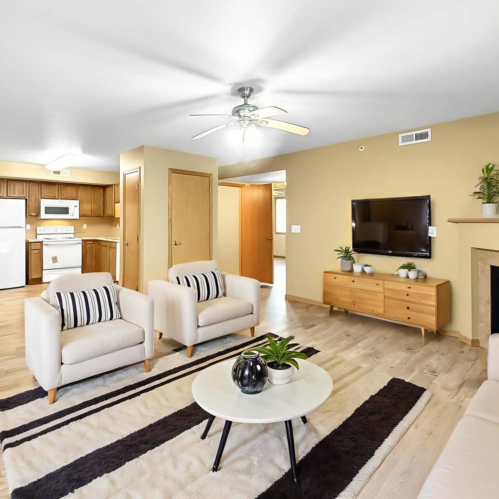 Living room with couch, chairs, flat screen television and view to kitchen at Prairie Bend in Cedar Rapids, Iowa