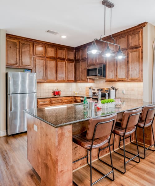 An apartment kitchen with an island at Huntsville Village Apartments in Huntsville, Texas