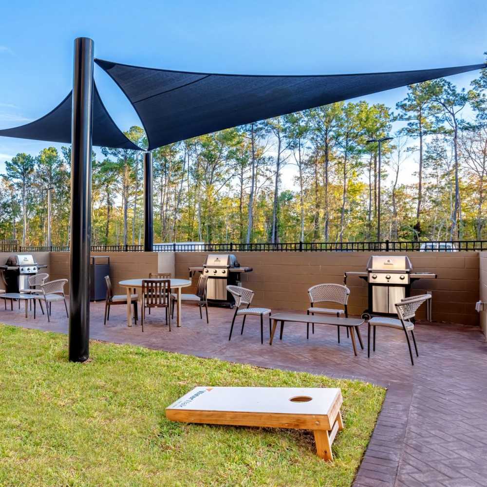 Outdoor grilling area with shaded seating at WaterWalk Jacksonville - Deerwood Park in Jacksonville, Florida