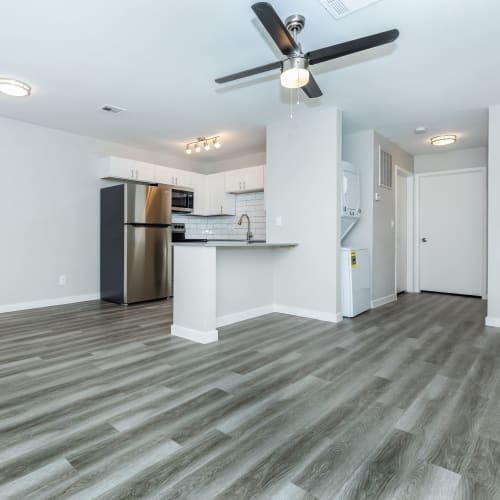 Spacious living room and kitchen with wood-style flooring at Tides on Palm in Las Vegas, Nevada