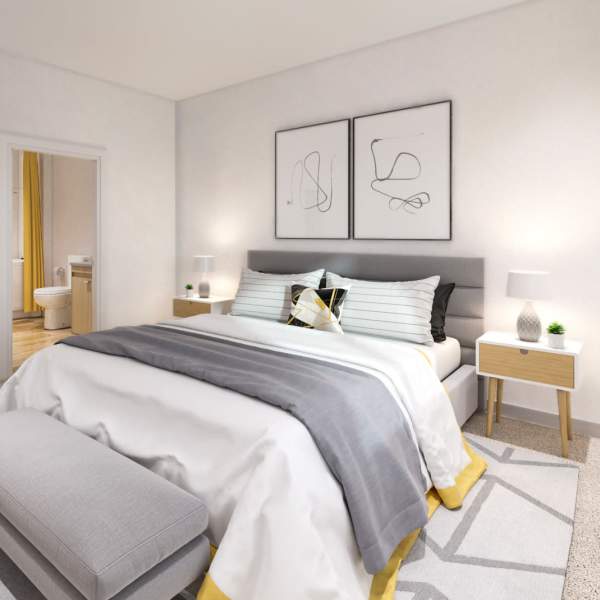 Full size bed with gray upholstered headboard and gray covers at Green Leaf Shoreline in Shoreline, Washington